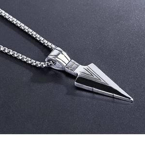 Macro shot of silver arrowhead pendant with intricate geometric punk textures