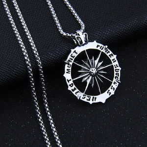 Gros plan du pendentif boussole solaire hip hop avec gravure Monet sur une chaîne box