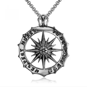Detailed macro view of retro sun god compass pendant with motivational text on steel chain