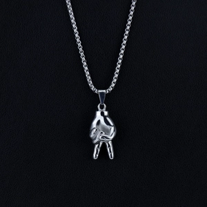 Macro shot of silver metal heart gesture pendant with smooth stainless steel chain links
