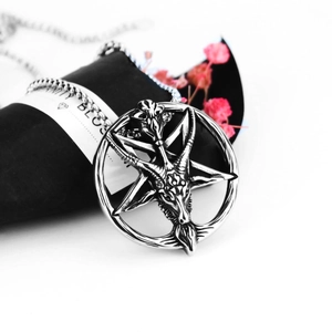 Detailed close-up of retro stainless steel goat head pendant necklace on jewelry pouch