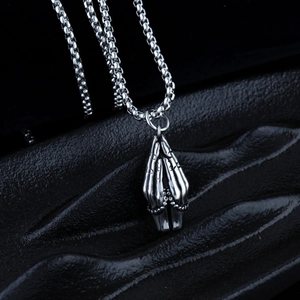 Detailed close-up of praying hands pendant in silver-tone stainless steel with box chain