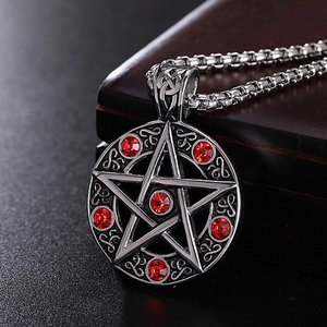 Detailed shot of Satanic pentagram necklace with red rhinestones and Celtic knot patterns