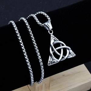 Close-up of vintage Triquetra Celtic knot pendant on a box chain with detailed textures
