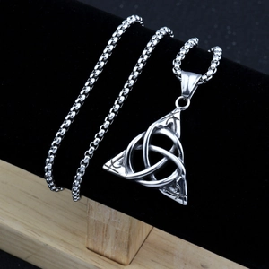 Close-up of silver Celtic knot pendant on black velvet stand with square pearl chain