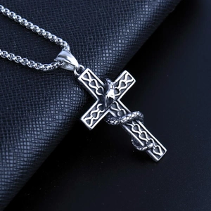 Macro shot of Gothic snake wrapped cross pendant with polished metallic finish