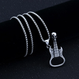 Détail d'un pendentif guitare crâne vintage avec décapsuleur sur support velours