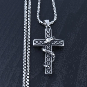 Macro shot of a gothic silver pendant featuring a snake wrapped around a cross
