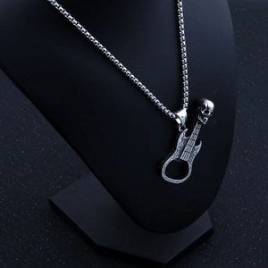 Détail du collier pendentif guitare crâne argenté sur un présentoir à bijoux noir