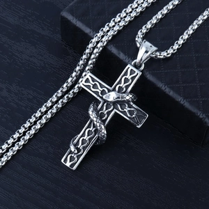 Macro shot of a gothic snake wrapped around a vintage stainless steel cross pendant