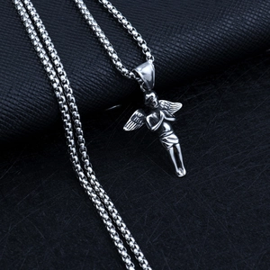 Détail macro d'un pendentif ange en argent avec ailes sur fond en cuir noir élégant