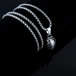 Macro shot of a polished silver grenade pendant with a textured finish and sturdy chain