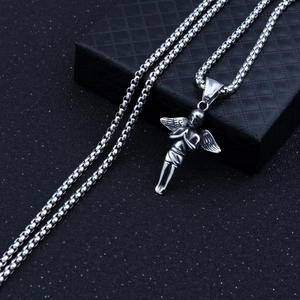 Détail d'un pendentif d'ange en prière argenté sur une chaîne boîte et un coffret à bijoux