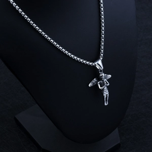 Gros plan détaillé du pendentif ange 3D argenté sur un collier à billes métal