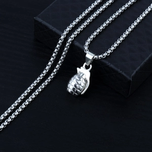 Macro shot of a silver grenade pendant necklace on a black diamond pattern jewelry box