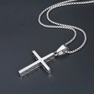 Makroaufnahme von poliertem Edelstahl-Kreuzanhänger mit vertieftem Kreuz-Detail