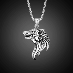 Detailed close-up of a carved silver wolf head pendant with intricate metallic textures