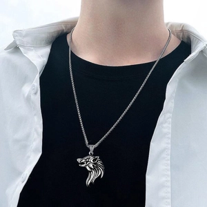 Close-up of a silver viking wolf head pendant necklace on a male model with punk style