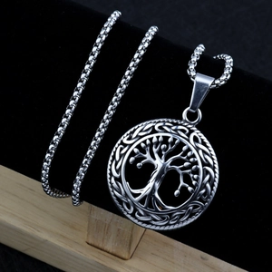 Detailed close-up of tree of life pendant with celtic knot on a silver box chain necklace