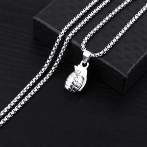 Polished silver grenade pendant necklace for men with box chain on dark wood background