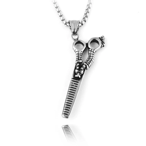 Détail du pendentif ciseaux et peigne en argent vintage avec finition métal texturé