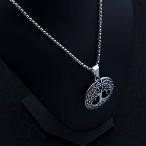 Silver tree of life pendant necklace displayed on a black neck bust at a 45-degree angle