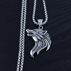 Detailed macro view of vintage wolf head pendant on a stainless steel box chain