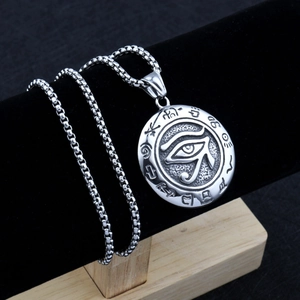 Macro detail of silver Eye of Horus pendant with Egyptian characters on a box chain
