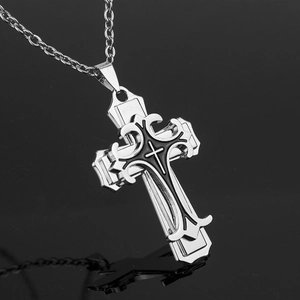 Vue macro du pendentif croix gothique multicouche avec émail noir sur une chaîne argentée