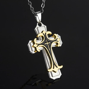 Vue détaillée du pendentif croix multicouche montrant la texture dorée et l'acier argenté
