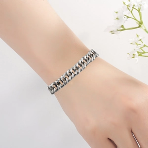 Vue détaillée d'un bracelet gourmette en acier inoxydable argenté au poignet avec fleurs