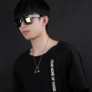 Détail du collier hip hop avec pendentif casque doré sur une longue chaîne