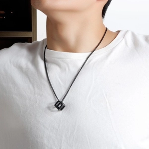 Minimalist black hollow cube pendant necklace shown on male model with white T-shirt