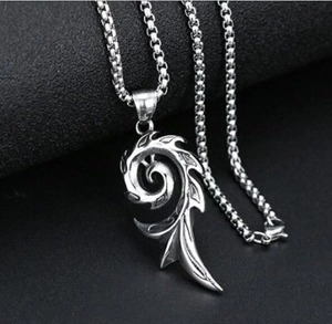Macro detail of vintage tribal flame pendant with oxidized silver finish and box chain
