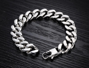 Macro detail of polished silver stainless steel Cuban chain bracelet with lobster clasp