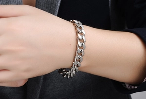 Close-up of a silver Cuban link bracelet made of stainless steel on a male wrist