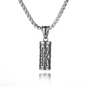 Macro shot of silver retro prayer cylinder pendant with engraved religious symbols