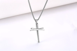 Détail du pendentif croix en clou argenté avec design de batte de baseball sur la chaîne