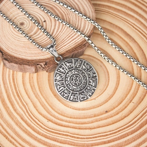 Gros plan du pendentif boussole Viking Vegvisir sur une texture boisée rustique