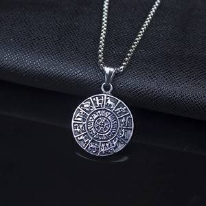 Détail du pendentif boussole Viking argenté avec runes nordiques sur cuir noir texturé