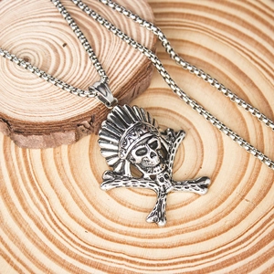 Close-up of vintage steel Indian skull pendant with feathers on wood grain texture