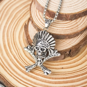 Macro view of vintage titanium steel Indian skull pendant with crossed bones on wooden background
