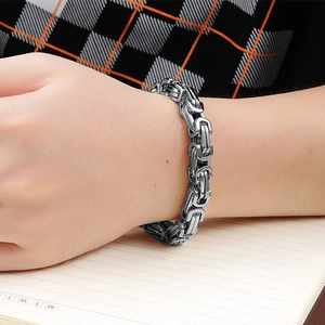 Detailed view of heavy silver stainless steel box chain bracelet worn on wrist