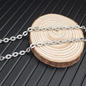 Detailed macro view of high-polished stainless steel O-chain links on wood texture