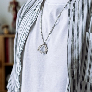 Collier minimaliste en argent avec pendentif double losange géométrique porté sur tenue