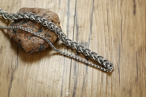 Close-up of titanium steel double layer wheat and box chain bracelets for men on stone