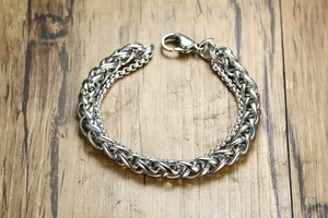 Detail of silver double-layered men's bracelet with wheat and box chain texture
