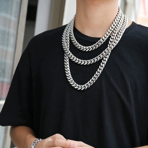 Silver Cuban link necklace and bracelet set layered on a model with black shirt background