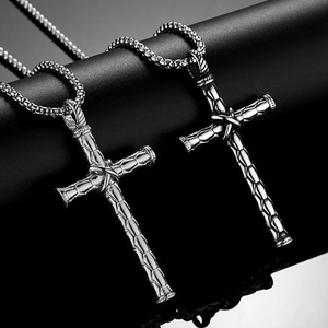 Détail macro du pendentif croix en argent avec texture écaillée et chaîne à mailles
