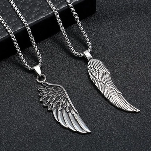 Gros plan détaillé du pendentif aile d'ange rétro sur un collier en métal argenté